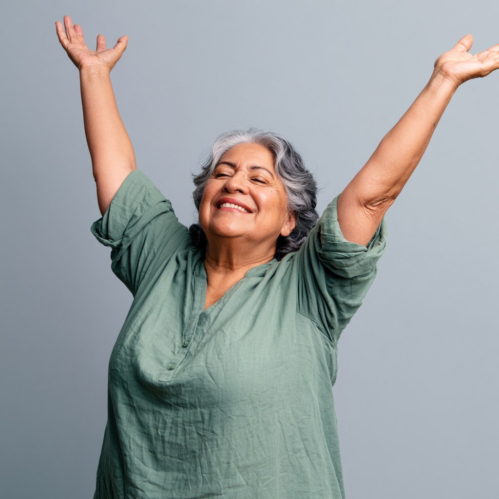 Mujer mayor sonriente y llena de energía levantando los brazos, simbolizando vitalidad y bienestar